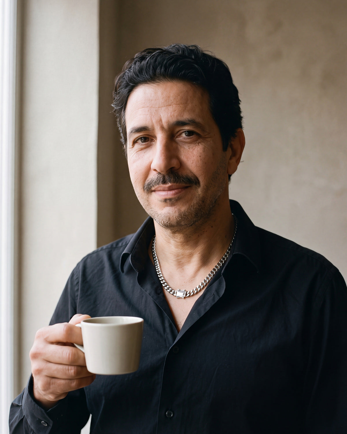 Man in a black shirt holding a coffee cup, wearing the 6 mm silver Atlas mirror-polished Cuban chain