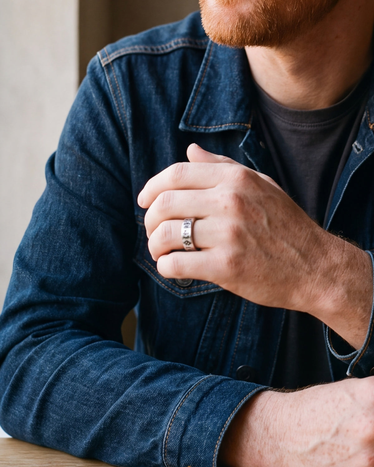 Close-up of a man's hand wearing the Atlas Norse rune band ring at true size