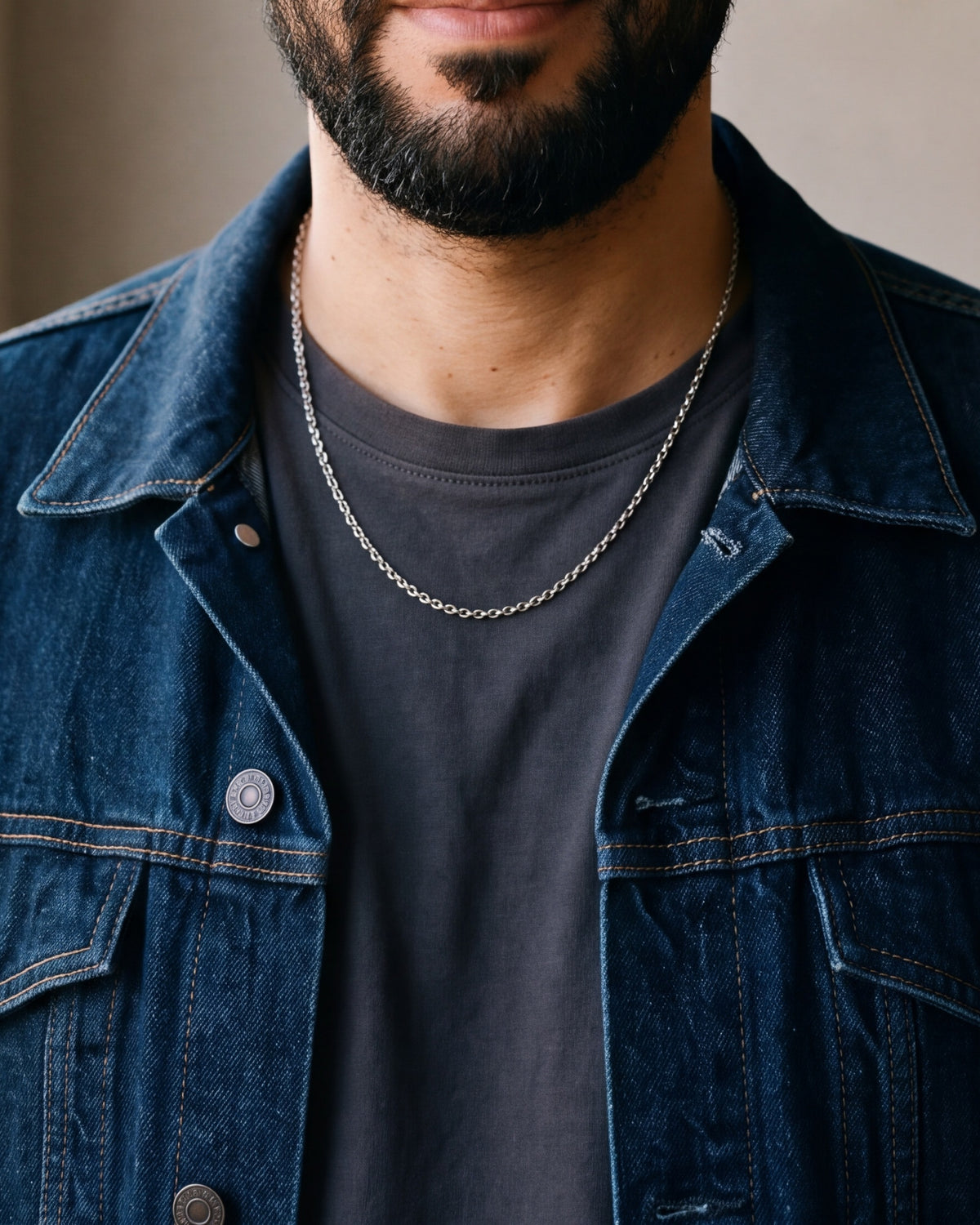 Close-up of the silver-tone Atlas O-link chain worn by a man, shown at true size