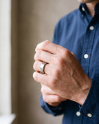 Close-up of the silver-tone Atlas Oak Wood Inlay Ring worn at true size