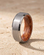 The whole silver-tone Atlas Oak Wood Inlay Ring lying on warm travertine stone