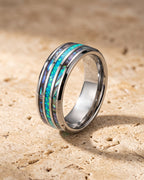 The whole silver-tone Atlas opal and abalone inlay ring lying on warm travertine stone