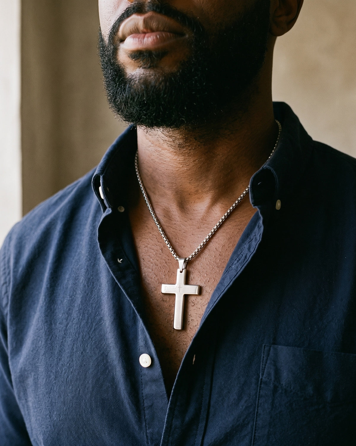 Atlas Our Father engraved cross pendant necklace in silver-tone titanium steel worn on the chest, close-up