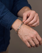 Hand adjusting the Atlas Paperclip Link Bracelet in Titanium Steel on the wrist