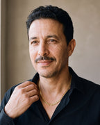 Smiling man in a black open-collar shirt wearing the gold-tone Atlas polished Cuban chain