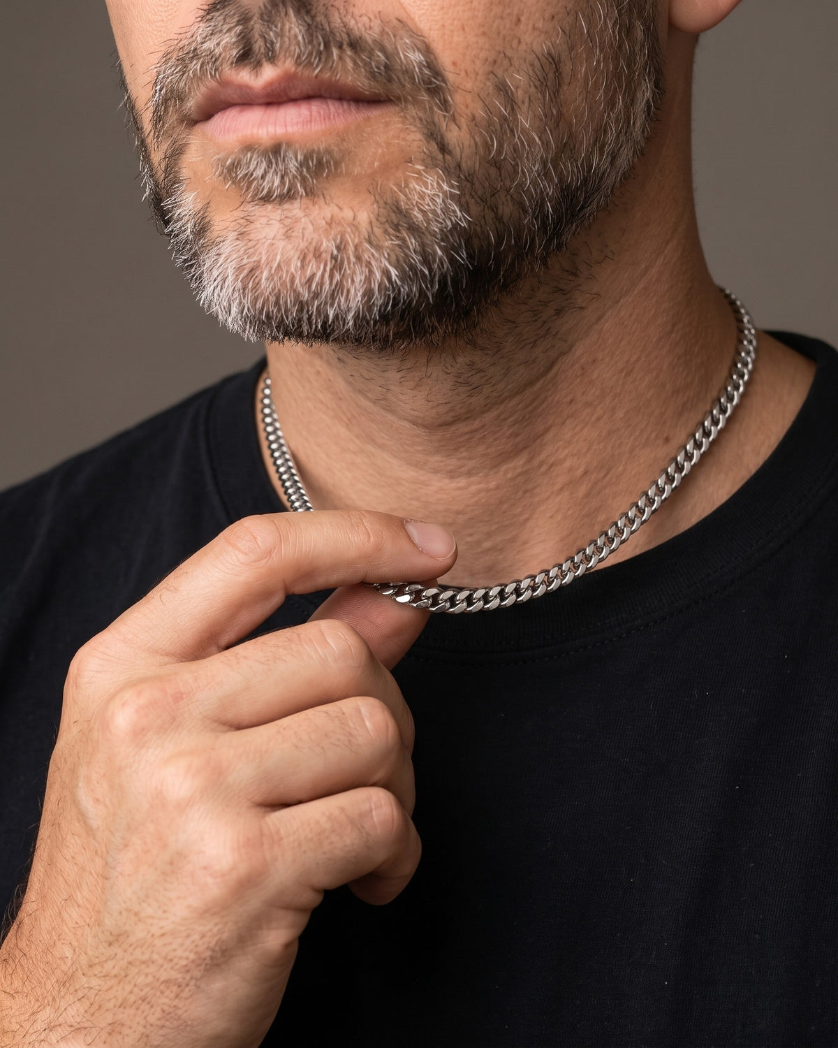 Hand lifting the Atlas Polished Cuban Chain in Titanium Steel at the collarbone