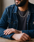 Close-up of the silver-tone Atlas polished curb link chain worn by a man, shown at true size