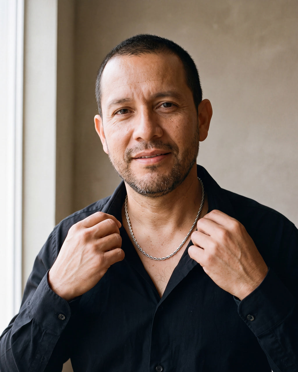 Man in a black fine cotton shirt by a window wearing the silver-tone Atlas Polished Rope Chain