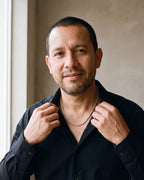 Man in a black fine cotton shirt by a window wearing the silver-tone Atlas Polished Rope Chain