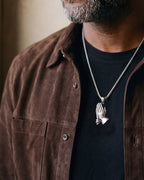 Close-up of the silver-tone Atlas praying hands pendant necklace worn, true size