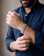 Close-up of the silver Atlas President link bracelet on a man's wrist at true size