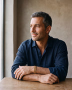 Second man in a dark navy linen shirt wearing the gold-tone Atlas president link bracelet