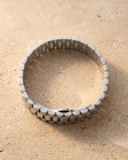 The whole silver Atlas President link bracelet closed, lying on warm stone