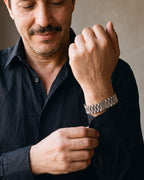 Close-up of the silver-tone Atlas President link bracelet on a man's wrist
