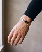 Close-up of the gold-tone with black stones Atlas president link inlay bracelet worn at true size