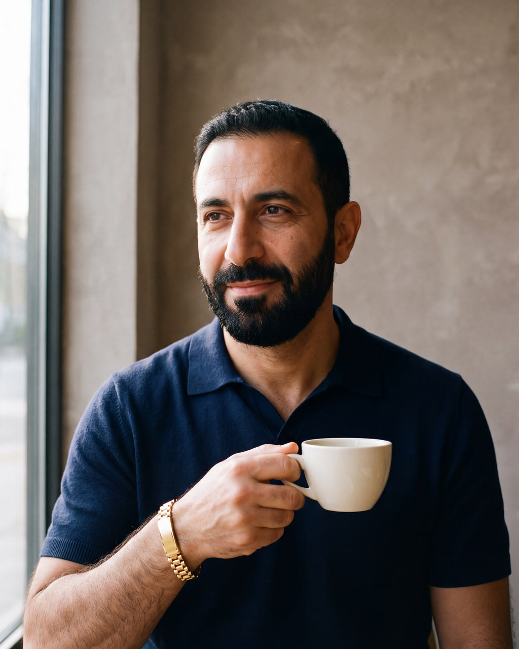 Second man in a navy fine-gauge knit polo with an open collar wearing the gold-tone Atlas president link inlay bracelet