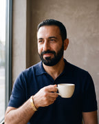 Second man in a navy fine-gauge knit polo with an open collar wearing the gold-tone Atlas president link inlay bracelet