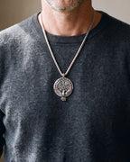 Close-up of the Atlas raven Vegvisir compass pendant worn on a charcoal sweater