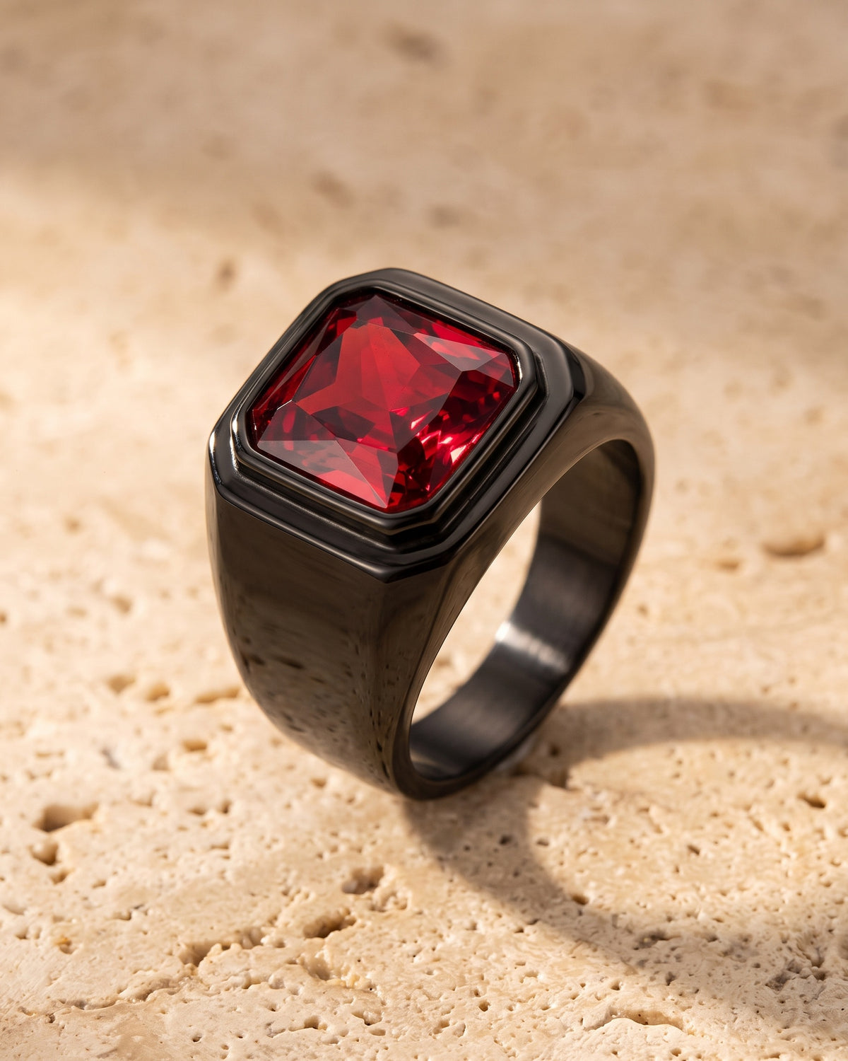 The whole black Atlas red stone signet ring laid on warm stone
