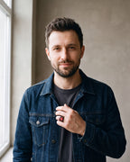 Man in a denim jacket over a charcoal T-shirt wearing the black Atlas red stone signet ring