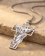 Close-up of the silver-tone Atlas Risen Christ openwork cross on warm stone