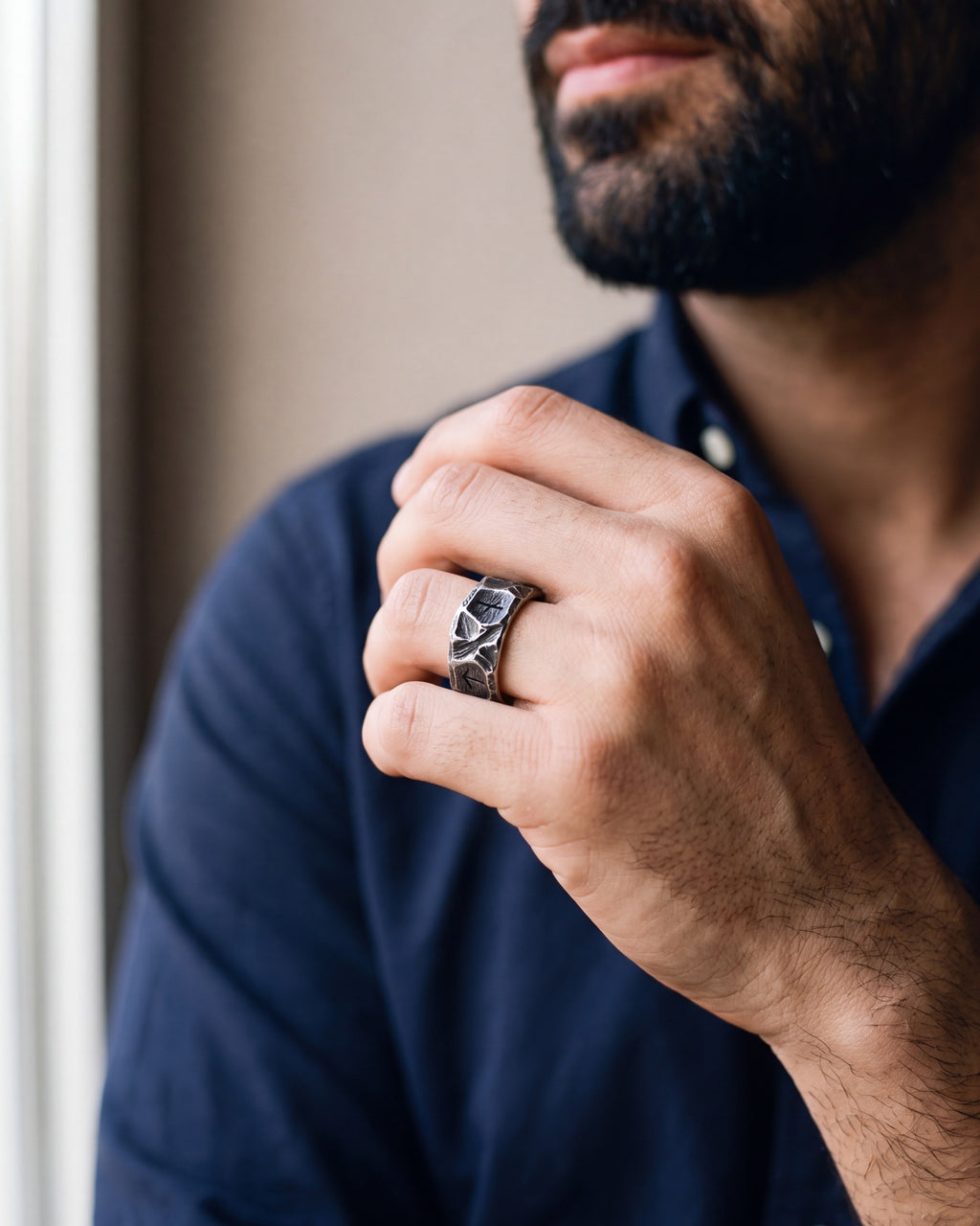 Close-up of a man's hand wearing the Atlas rock texture rune ring