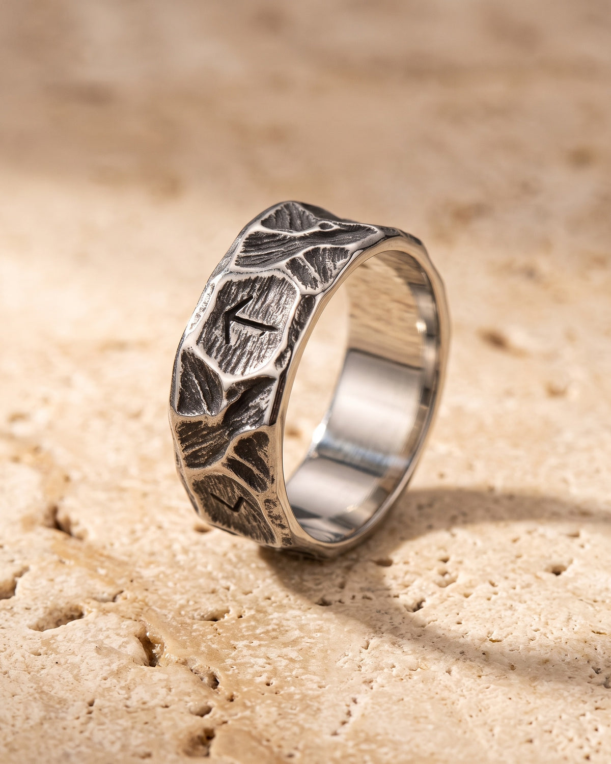 The Atlas rock texture rune ring standing on warm stone