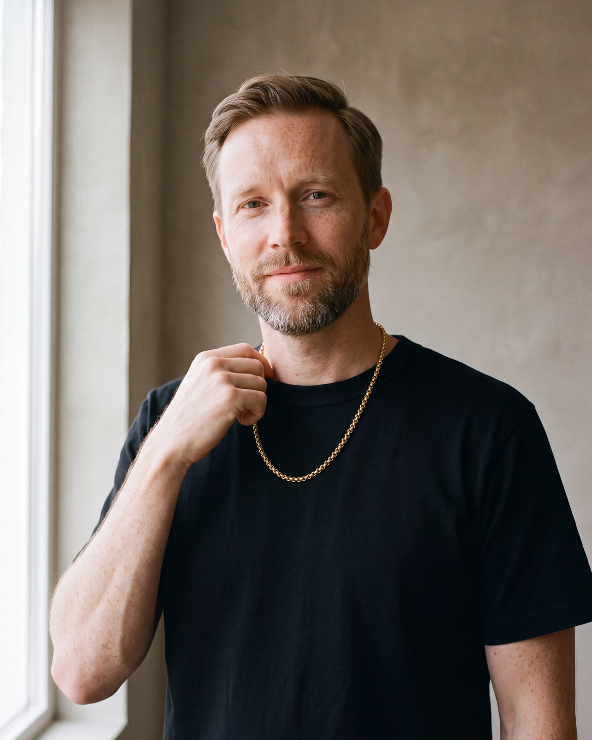 Man in a heavyweight black cotton crew-neck t-shirt wearing the gold-tone Atlas Rolo Chain