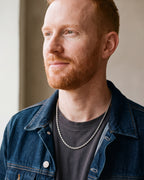 Man in a denim jacket in profile by a window, wearing the 2.5 mm silver Atlas rope chain