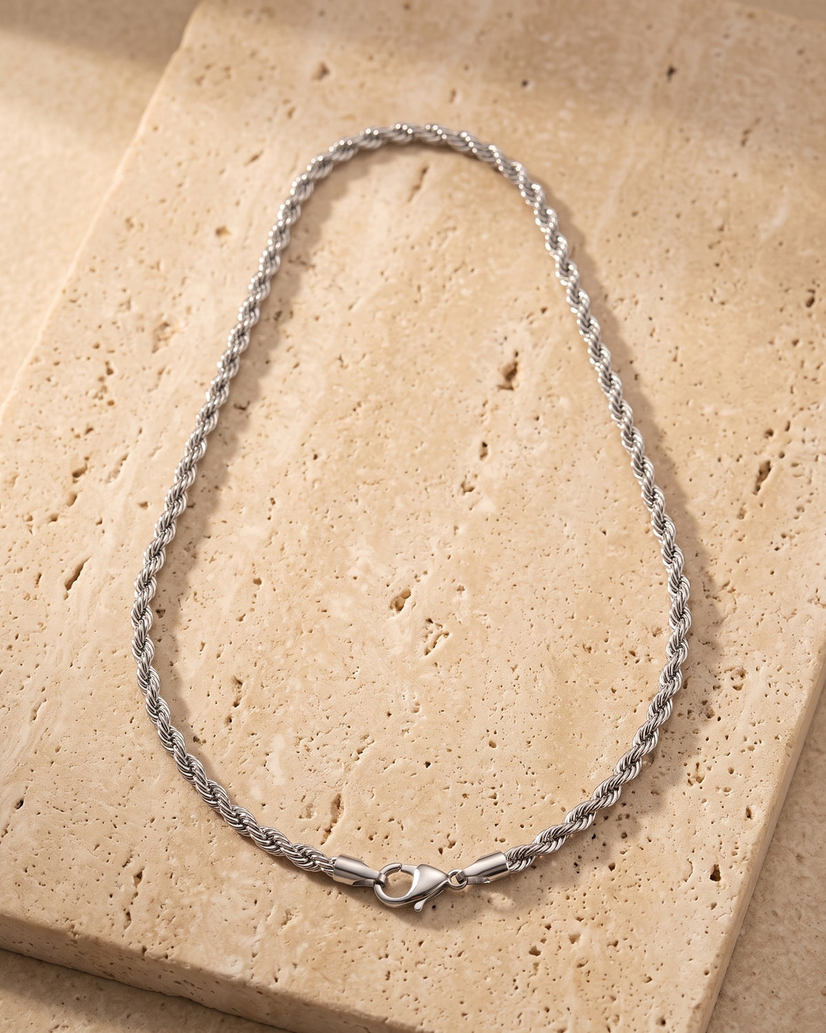 Atlas stainless steel rope chain laid whole on warm stone
