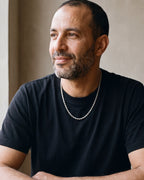 Man in a black t-shirt seated at a wooden table, wearing the 4 mm Atlas rope chain