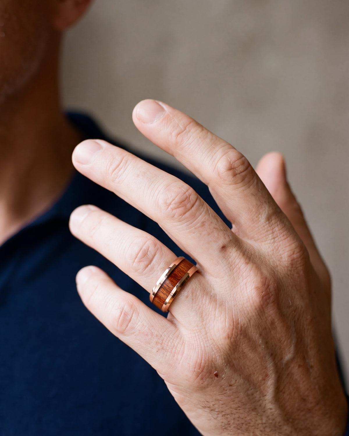 Close-up of the Atlas rose gold-tone wood inlay ring on a man's hand