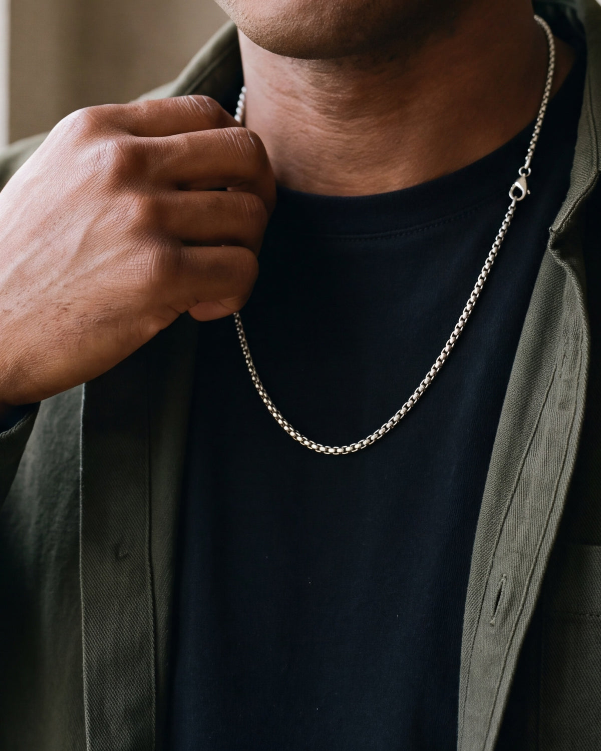 Close-up of the 3 mm silver Atlas round box chain worn on a black T-shirt at true size