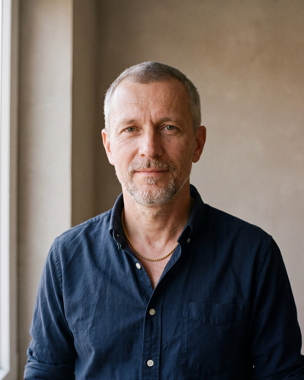Man in a navy shirt wearing the gold-tone Atlas rounded box chain