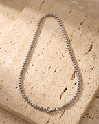 The whole silver-tone Atlas rounded box chain on warm stone, lobster clasp