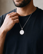 Close-up of the Atlas two-sided Saint Benedict medal necklace in silver-tone steel, worn at true size
