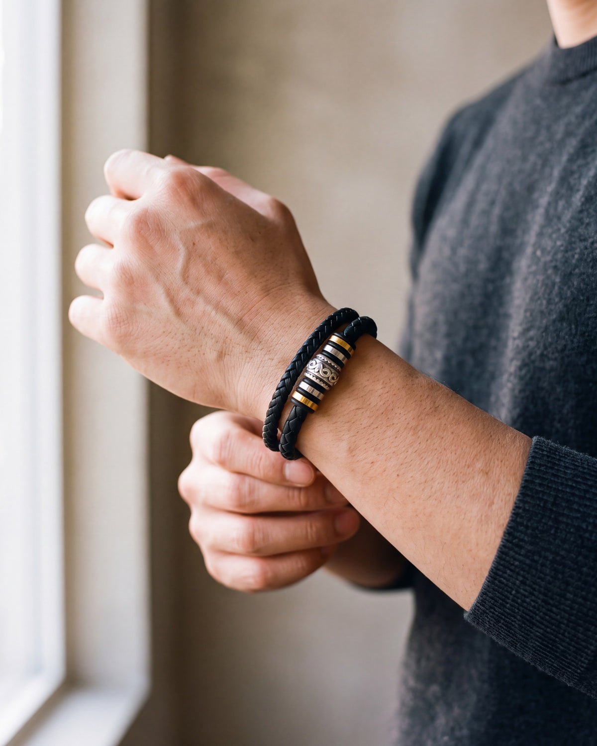 Close-up of the black Atlas scrollwork bead braided leather bracelet worn by a man, shown at true size