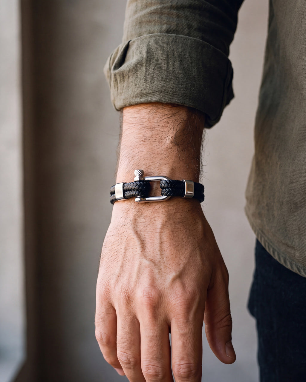 Close-up of the silver-tone / black Atlas Shackle Bracelet in Braided Leather worn at true size