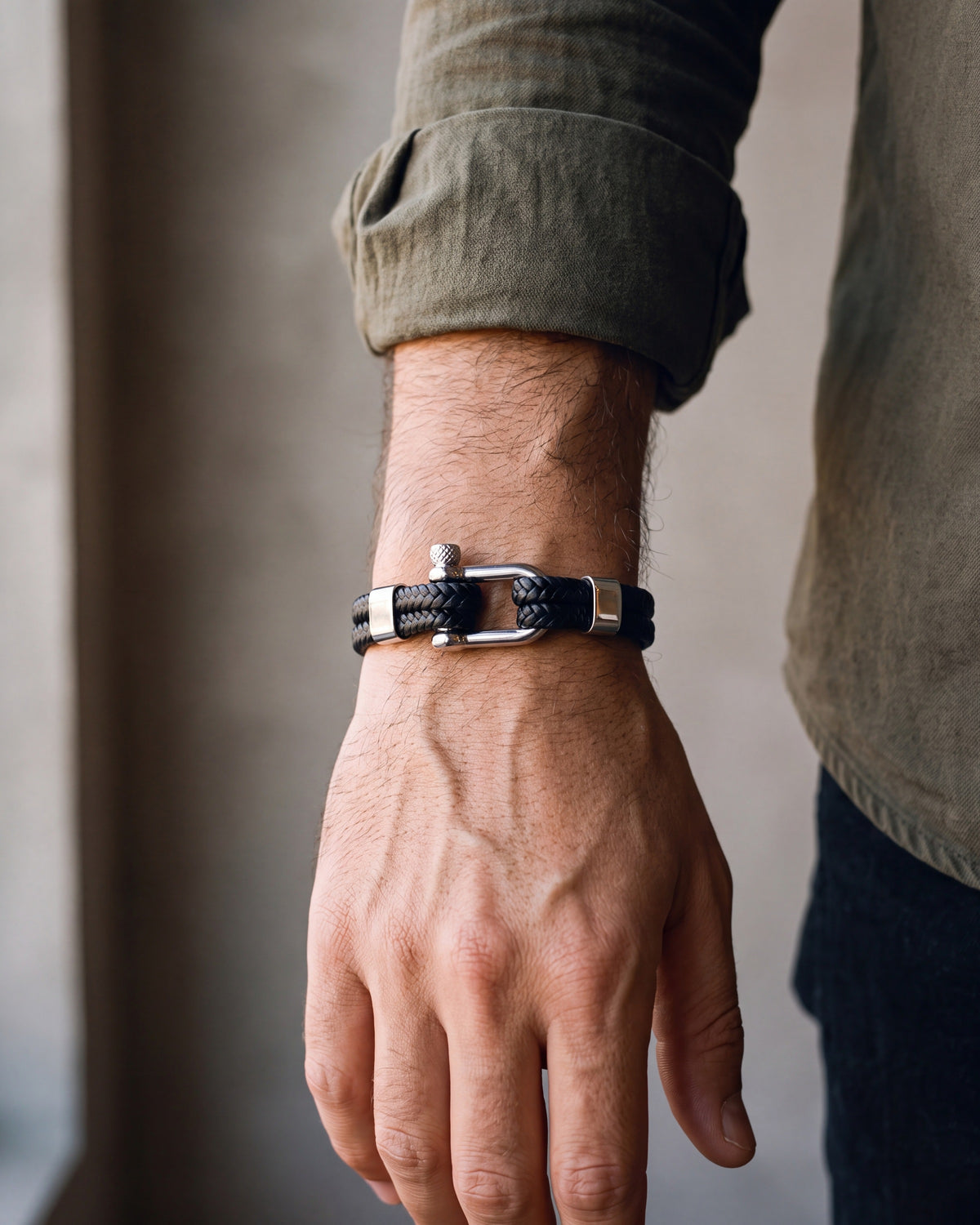 Close-up of the silver-tone / black Atlas Shackle Bracelet in Braided Leather worn at true size