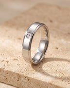 The Atlas single cubic zirconia band standing on warm stone