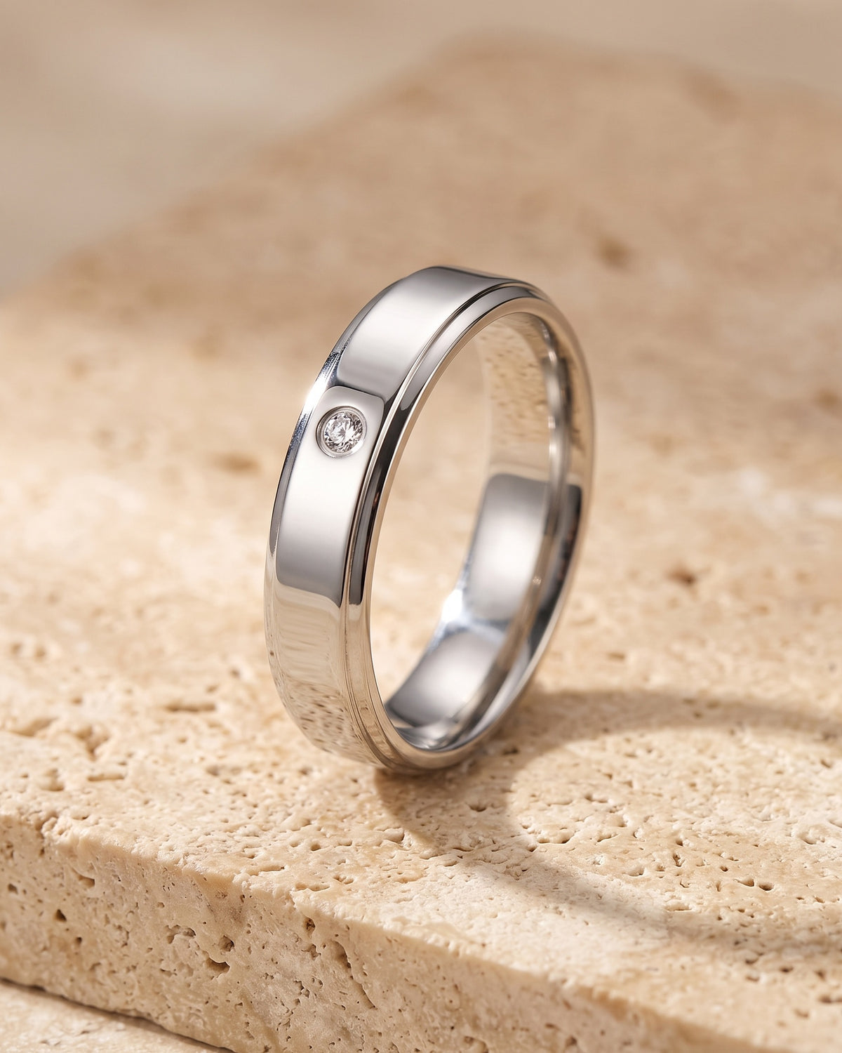 The Atlas single cubic zirconia band standing on warm stone