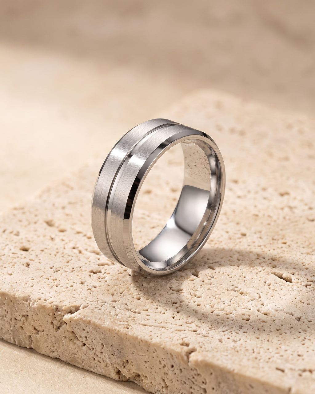 Atlas single groove band ring standing on warm stone