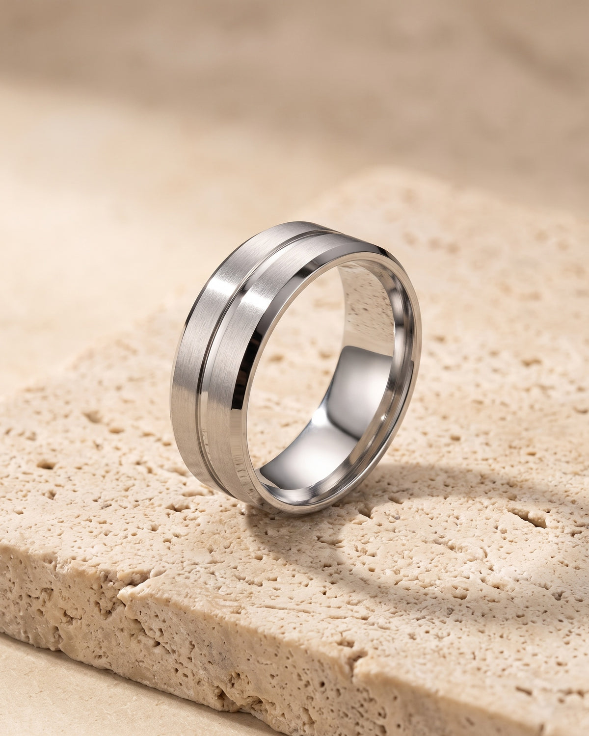 Atlas single groove band ring standing on warm stone