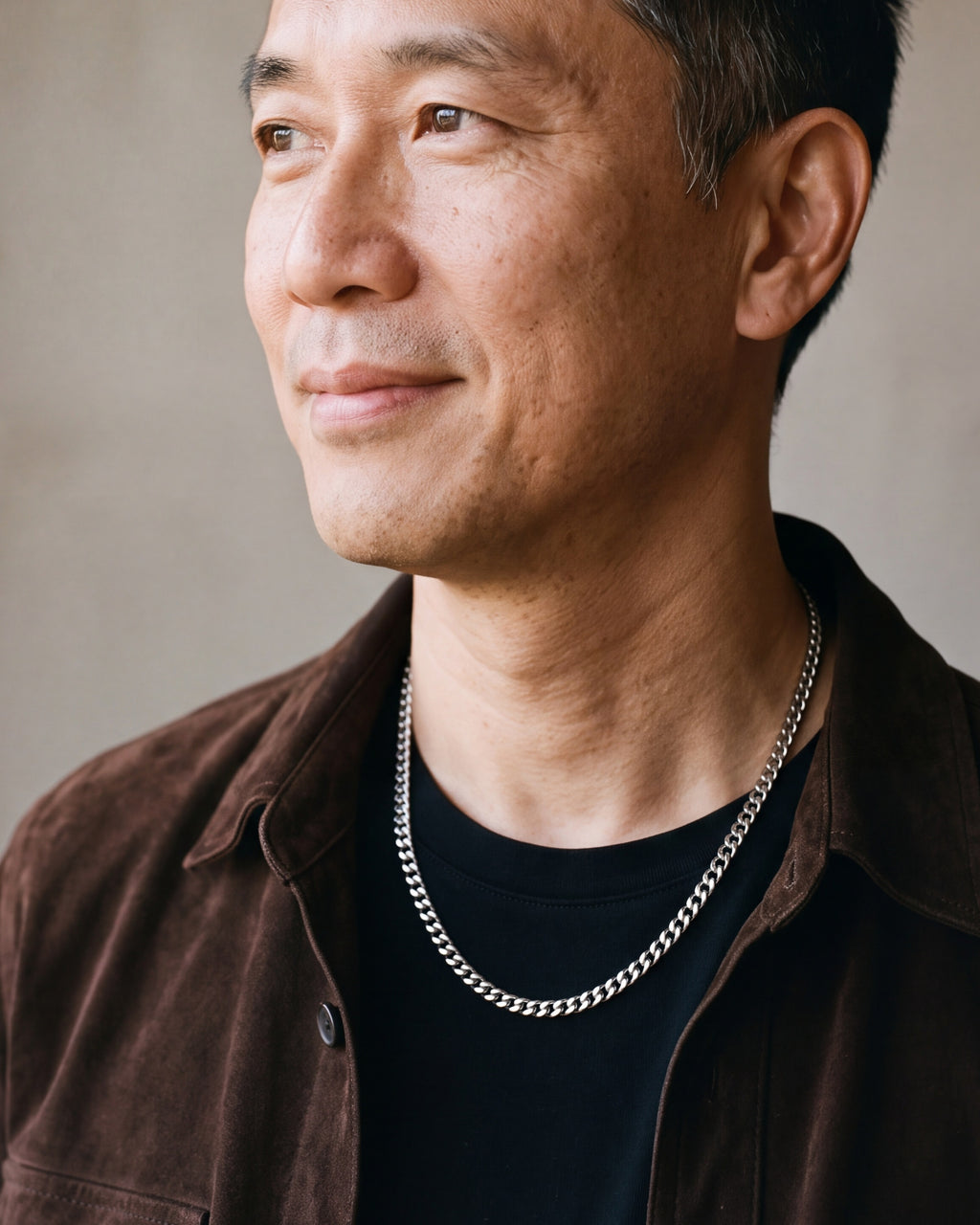 Man in a brown suede overshirt looking toward the window, wearing the 3 mm silver Atlas Cuban chain