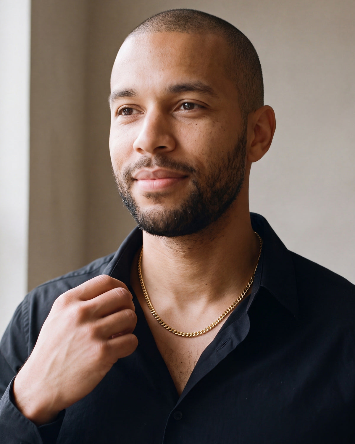 Man in a black shirt with his hand at the collar, wearing the 3 mm gold-tone Atlas Cuban chain