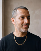 Man in a black merino sweater wearing the Atlas slim Figaro chain in gold-tone steel