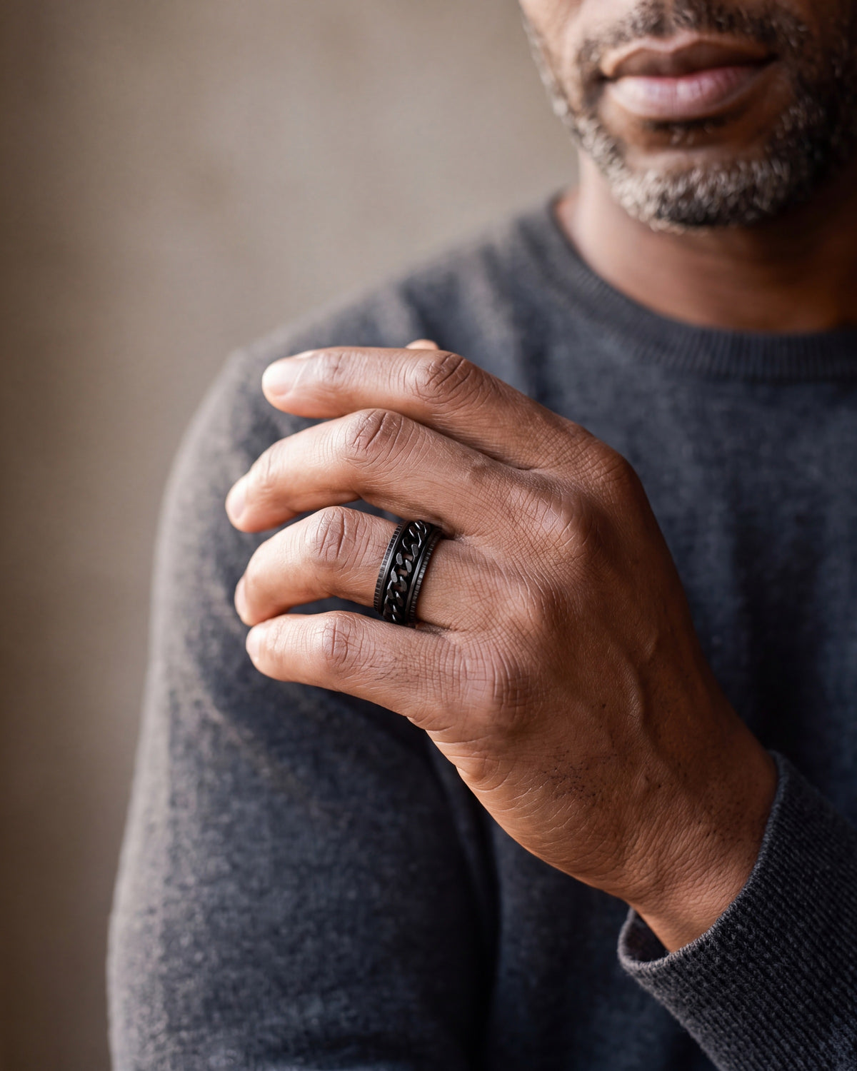 Close-up of the black Atlas spinner chain ring worn by a man, shown at true size