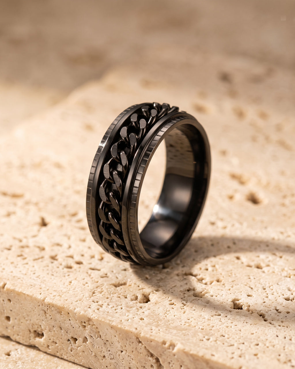 The whole black Atlas spinner chain ring laid on warm stone