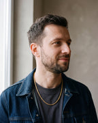 Man in a denim jacket over a charcoal T-shirt wearing the gold-tone Atlas spiral rope chain