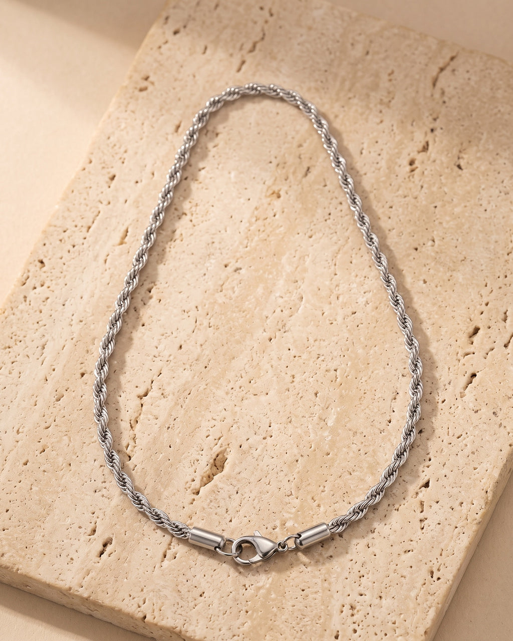 The whole silver Atlas spiral rope chain laid on warm stone